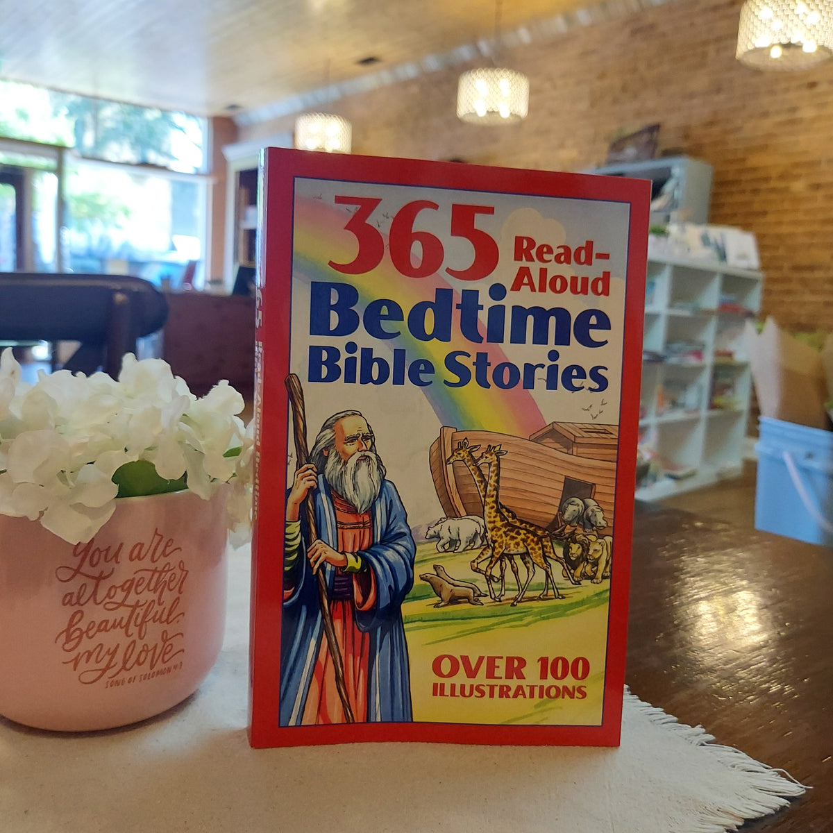 Book titled '365 Read-Aloud Bedtime Bible Stories' on a table with a blurred background